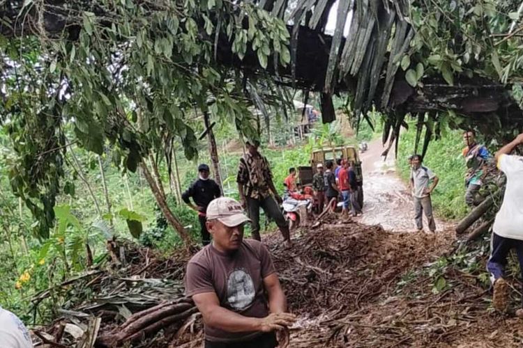 Warga tengah membersihkan material longsor yang menutup jalan di wilayah Kecamatan Campakamulya, Kabupaten Cianjur, Jawa Barat, Rabu (2/12/2020).