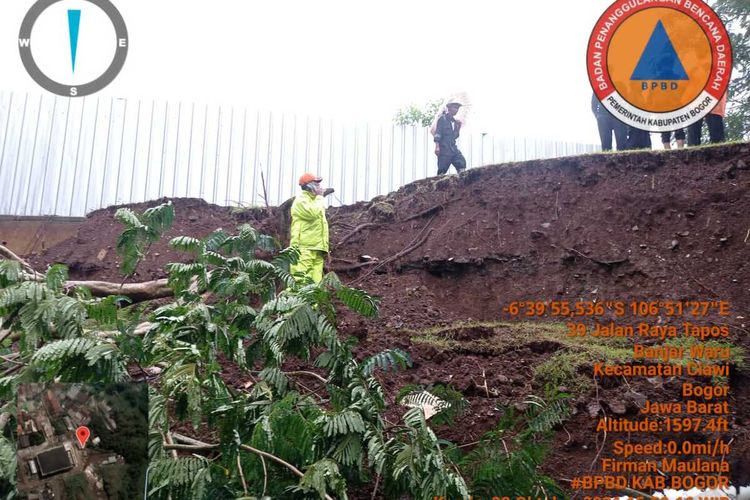 Sejumlah petugas sedang mengevakuasi pohon tumbang akibat longsor di Kawasan Puncak Bogor, Jawa Barat, Kamis (28/10/2021).