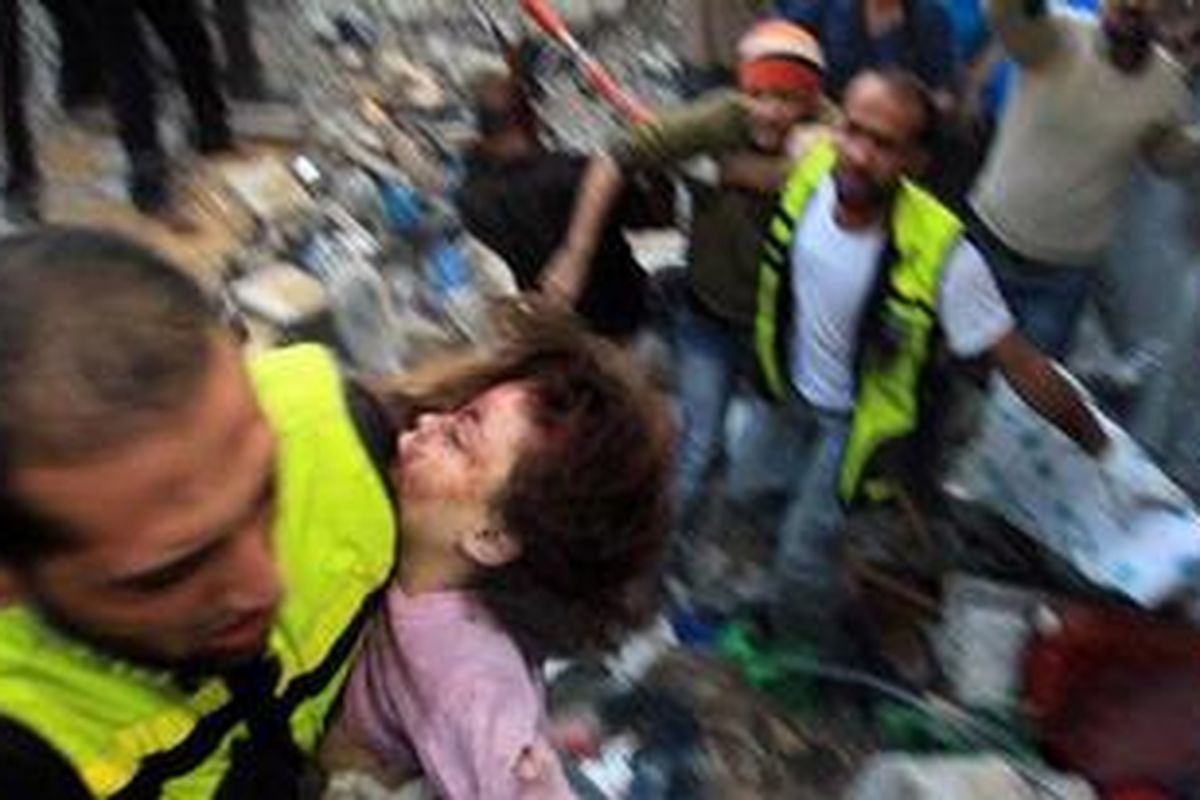 Warga Palestina membawa seorang anak dari keluarga Al-Dallu yang tewas dalam serangan misil Israel di Jalur Gaza, Minggu (18/11/2012).