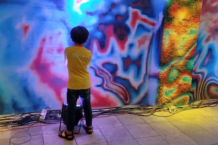 Seorang anak kecil tengah melihat mural Friends Mural karya kolaborasi seniman mural Indonesia dan Jerman di acara JAKBERFEST 2019, Sabtu (30/11/2019).