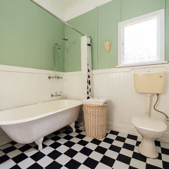Ilustrasi kamar mandi berdinding sage green dan lantai bermotif