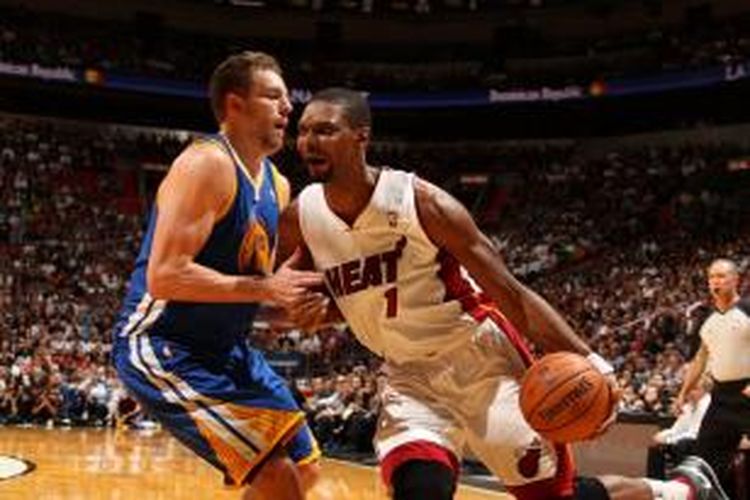 Pebasket Golden State Warriors, David Lee (kiri) mencoba menghalangi pergerakan pemain Miami Heat, Chris Bosh. Kedua tim bertemu pada laga lanjutan kompetisi NBA di American Airlines Arena, Miami, Kamis (02/01/2014).