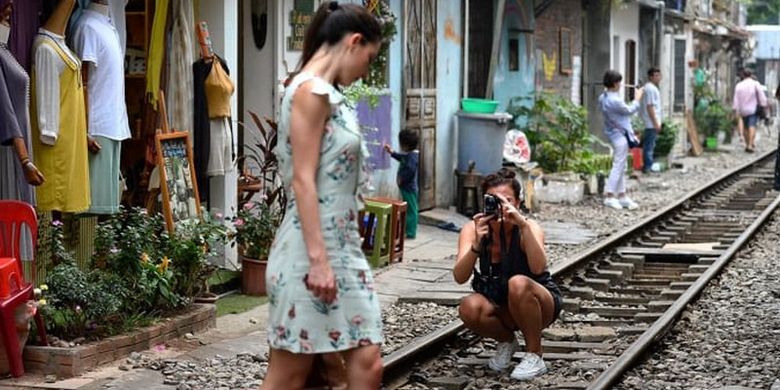 Turis berfoto di rel kereta Old Quarter, Vietnam.