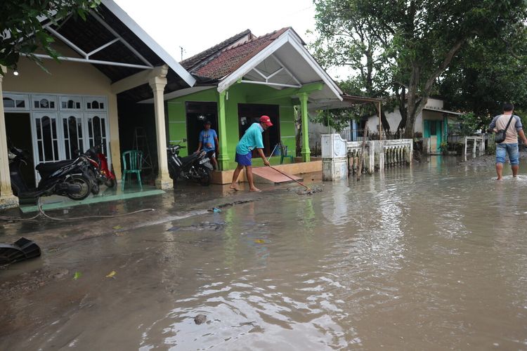 Warga Dusun Beluk, Desa Jombok, Kecamatan Kesamben, Kabupaten Jombang Jawa Timur, membersihkan sampah dan sisa lumpur akibat banjir, Jumat (15/1/2021).