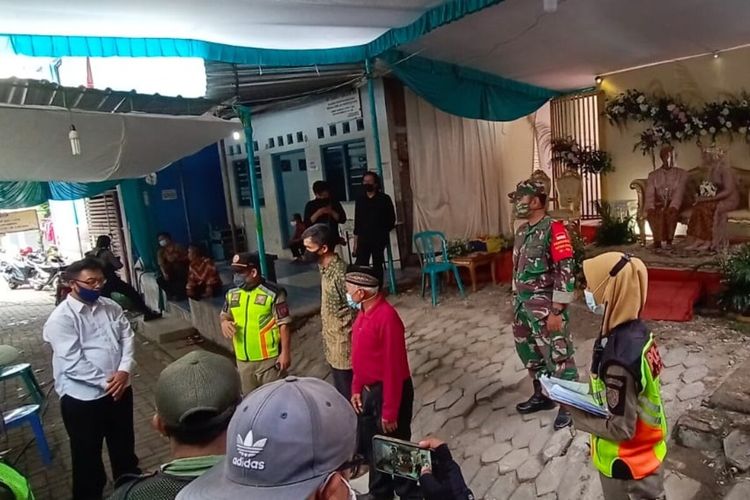 Satpol PP dan tim cipta kondisi saat menghentikan kegiatan hajatan di Solo, Jawa Tengah, Minggu (24/1/2021).
