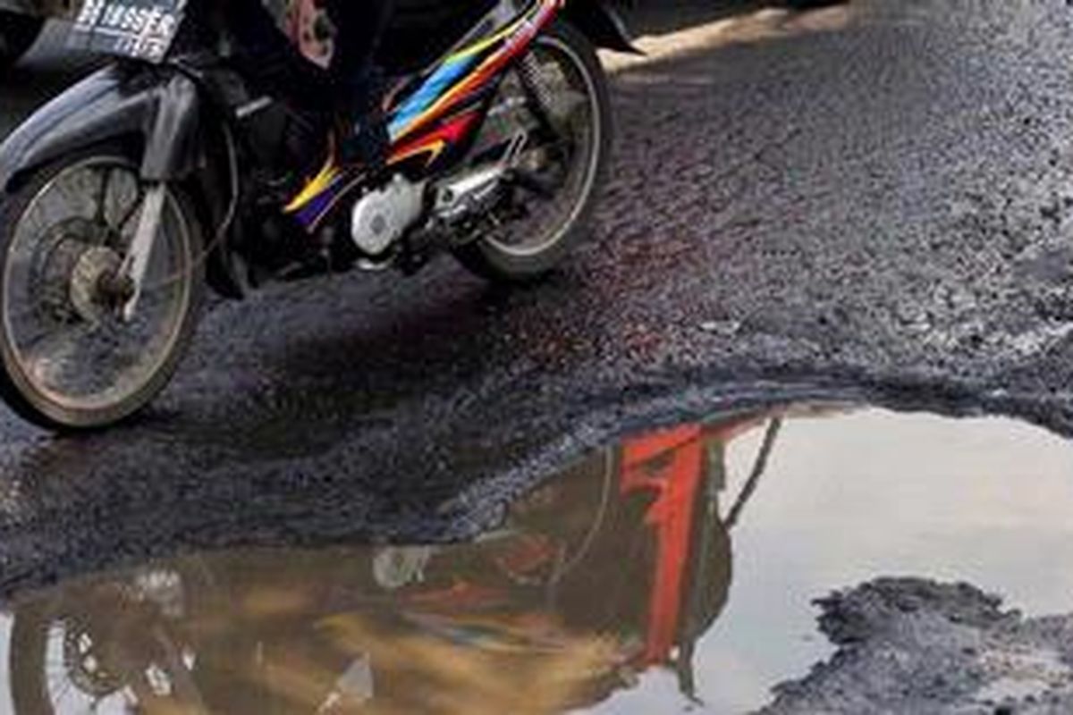 Ilustrasi: Pengendara motor menghindari kubangan air karena rusaknya aspal di Jalan Gunung Saharai, Jakarta, Senin (1/4/2013). Lubang di jalan yang tertutup genangan air sering membuat pengendara motor terperosok dan jatuh.