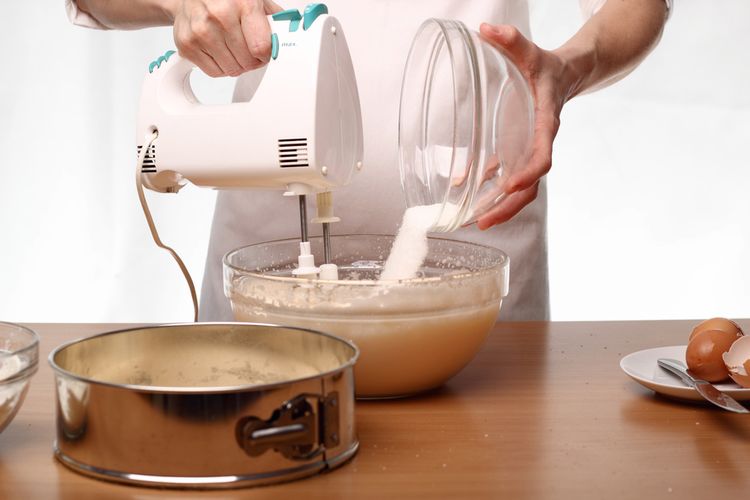 Ilustrasi mencampurkan bahan kue dengan hand mixer