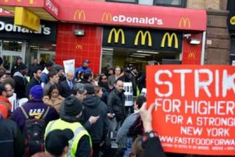 Koalisi kelompok pekerja restoran makanan siap saji melakukan protes di depan sebuah restoran McDonald's di Harlem, New York, April 2013.