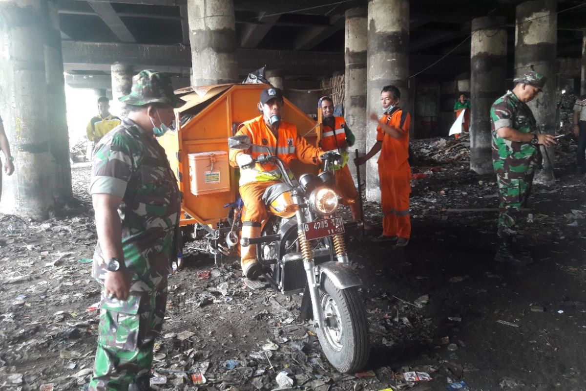 Sampah di kolong Tol Pelabuhan diangkut menggunakan gerobak motor pada Jumat (20/4/2018).