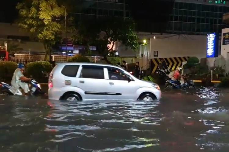 Sejumlah pengendara berusaha menerobos genangan air di Jalan Stasiun, Medan. 