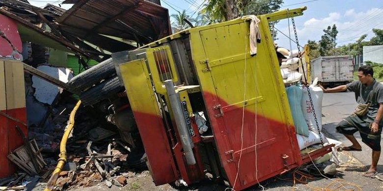 Truk pengangkut gabah terguling setelah menyeruduk toko di Jalan Brawijaya, Mangli, Jember, Kamis (18/3/2021). 