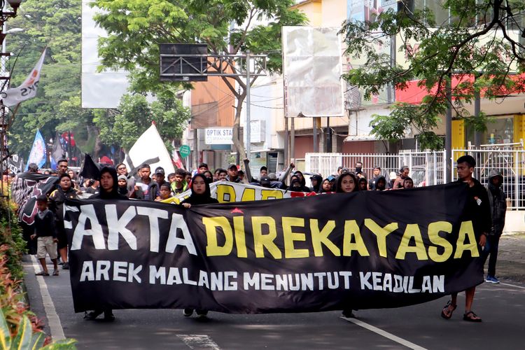 Suporter Arema, Aremania dan masyarakat melakukan aksi damai dengan membawa spanduk protes terkait Tragedi Kanjuruhan yang dilaksanakan di sejumlah titik Kota Malang, Minggu (04/12/2022) siang.