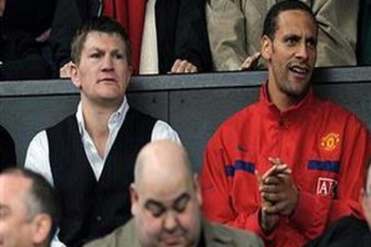 bek Manchester United Rio Ferdinand (kanan) hanya bisa duduk di bangku penonton untuk melihat timnya di bermain lawan Arsenal, Sabtu (16/5). Ferdinand masih cedera dan belum tentu tampil di final Liga Champions.