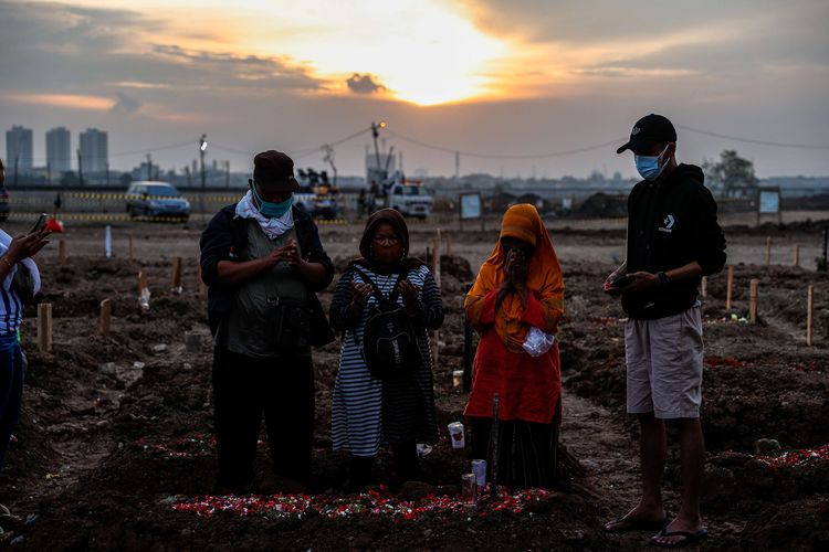 Keluarga mengantar pemakaman jenazah korban Covid-19 di TPU Rorotan, Jakarta Utara, Senin (28/6/2021). Meningkatnya kasus kematian Covid-19 mengakibatkan kesibukan pemakaman di TPU Rorotan hingga malam hari.