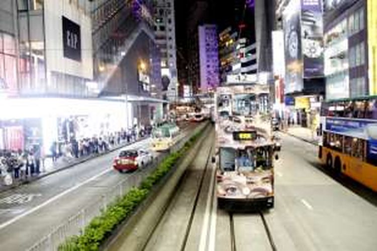 Moda transportasi umum di Hongkong yakni trem dan bus berjalan berdampingan di sudut jalan area Causeway Bay, Hongkong, Rabu (15/6/2016) malam. 