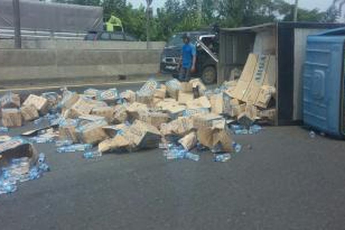 Truk pengangkut botol air mineral terguling di Tol Cikampek arah Jakarta, Senin (23/3/2015).