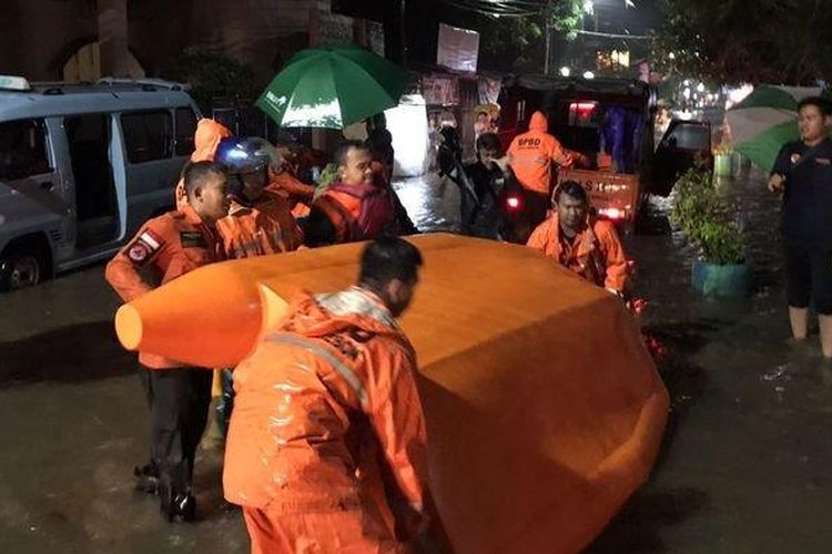 Sejumlah petugas BPBD Kota Cirebon saat mengerahkan perahu untuk mengevakuasi warga terdampak banjir di Kelurahan Pekiringan, Kecamatan Kesambi, Kota Cirebon, Selasa (25/10/2022) malam. 