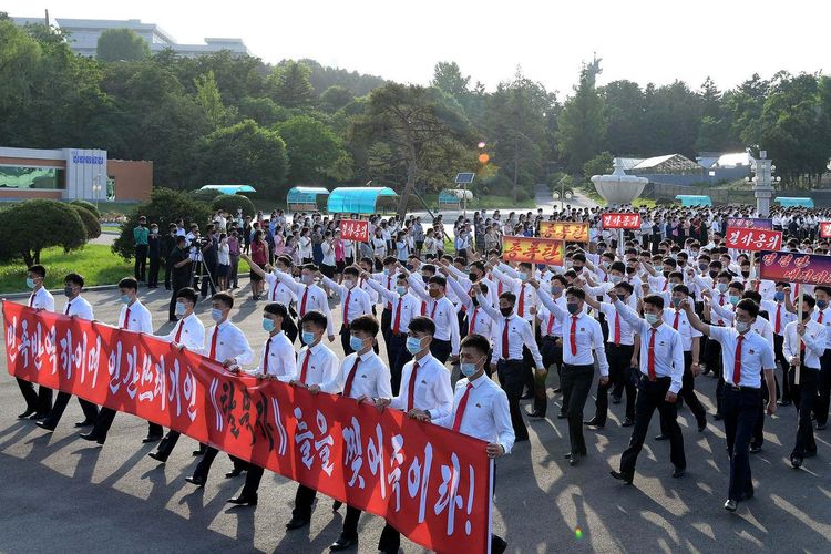 Para pemuda dan pelajar yang memakai masker berpartisipasi di demonstrasi menentang Korea Selatan dan pembelot Korea Utara. Foto ini diunggah oleh media pemerintah Korut KCNA pada 9 Juni 2020.