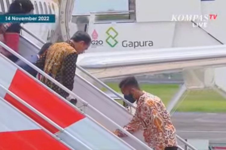 Presiden Joko Widodo menunggu Ibu Negara Iriana Joko Widodo berdiri usai terpeleset saat menuruni tangga Pesawat Kepresidenan RI 1 di Bandara I Gusti Ngurah Rai pada Senin (14/11/2022). 