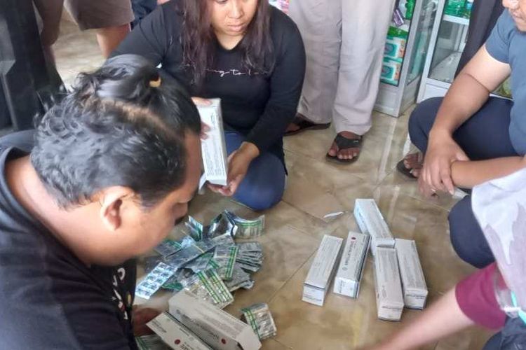 Anggota Satnarkoba Polres Dompu saat melakukan penggeledahan apotik yang menjual tramadol tanpa izin, Minggu (21/8/2022).