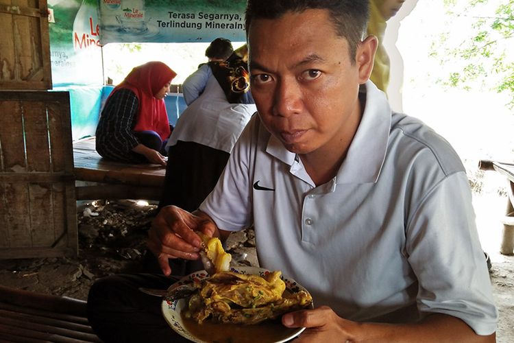 Salah seorang pengunjung saat menikmati kelan sembilang di warung milik Pak Kasan di Gresik, Jawa Timur, Rabu (9/1/2019).