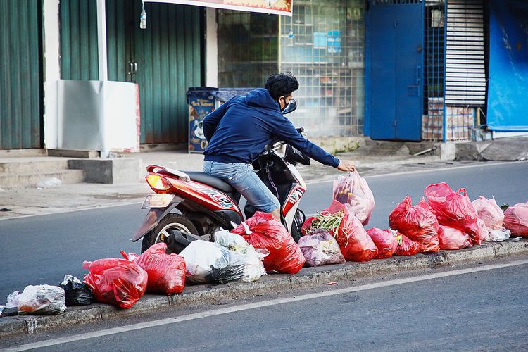 Warga yang mengendarai sepeda motor berhenti di tengah jalan untuk membuang sampah di separator jalan Raden Patah, Ciledug, Kota Tangerang, Banten, Jumat (7/1/2022). Kegiatan membuang sampah di separator jalan telah berlangsung lama. Setiap pagi petugas kebersihan mengangkut sampah-sampah yang memenuhi separator di jalan tersebut.

KOMPAS/PRIYOMBODO (PRI)
07-01-2022