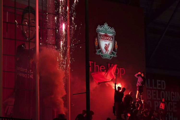 Beberapa fans merayakan keberhasilan Liverpool menjadi juara Premier League, kasta teratas Liga Inggris, musim 2019-2020 di depan Stadion Anfield, Liverpool, Inggris, Kamis (25/6/2020). Liverpool dipastikan menjuarai Liga Inggris 2019-2020 seusai kekalahan Manchester City dari Chelsea yang membuat mereka tak bisa mengejar 86 poin yang dimiliki The Reds, julukan Liverpool.