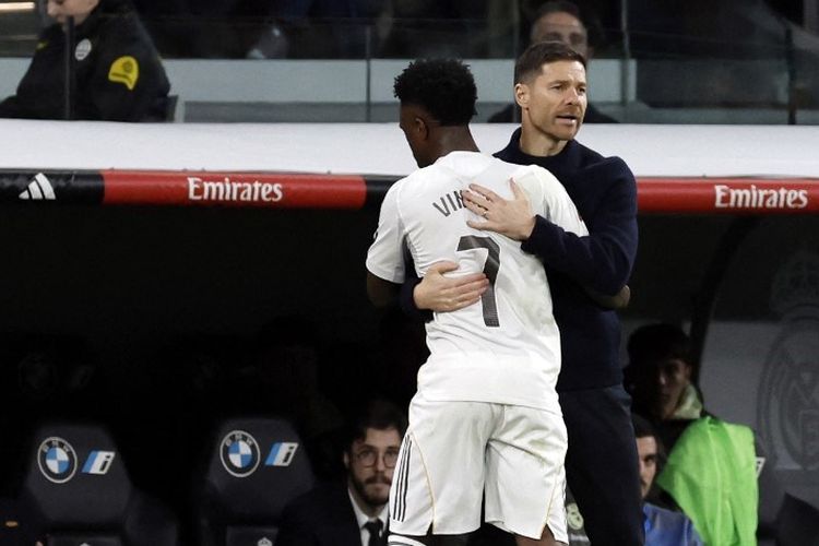 Xabi Alonso memeluk Vinicius Junior setelah diganti dalam pertandingan sepak bola Liga Spanyol antara Real Madrid vs Sevilla FC di Stadion Santiago Bernabeu di Madrid pada 20 Desember 2025. (Foto oleh Oscar DEL POZO / AFP)