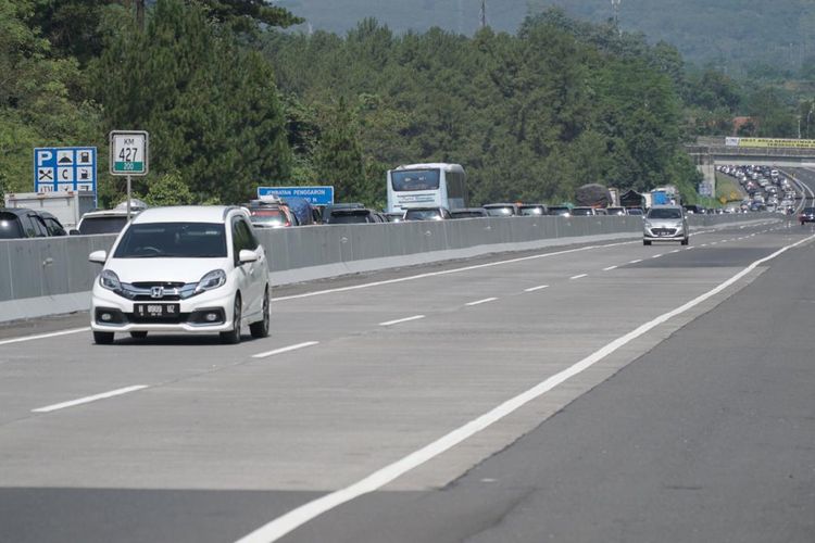 Ilustrasi mobil melintas di jalan tol