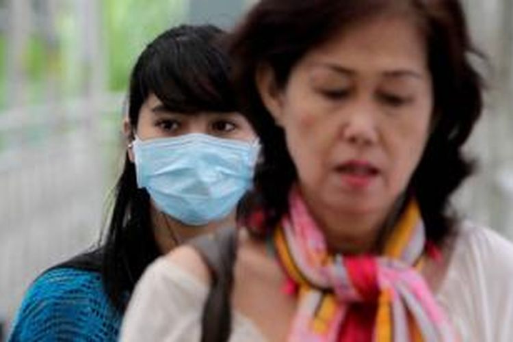Warga menggunakan masker ketika beraktifitas di sekitar Bundaran Hotel Indonesia, Jakarta Pusat, Kamis (11/4/2013).