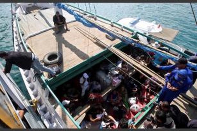 Para pencari suaka asal Iran di dalam perahu saat berada di Pelabuhan Benoa, Bali, usai ditangkap polisi di perairan Selat Badung, Minggu (12/5/2013). Para imigran gelap yang berjumlah 100 orang itu diperkirakan akan menuju Australia.