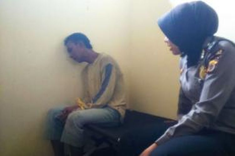 Seorang polisi wanita (Polwan) sedang menenangkan Muchri, terduga pencuri tabung gas di Mapolsek Lhoksukon, Aceh Utara, Aceh, Kamis (15/10/2015)