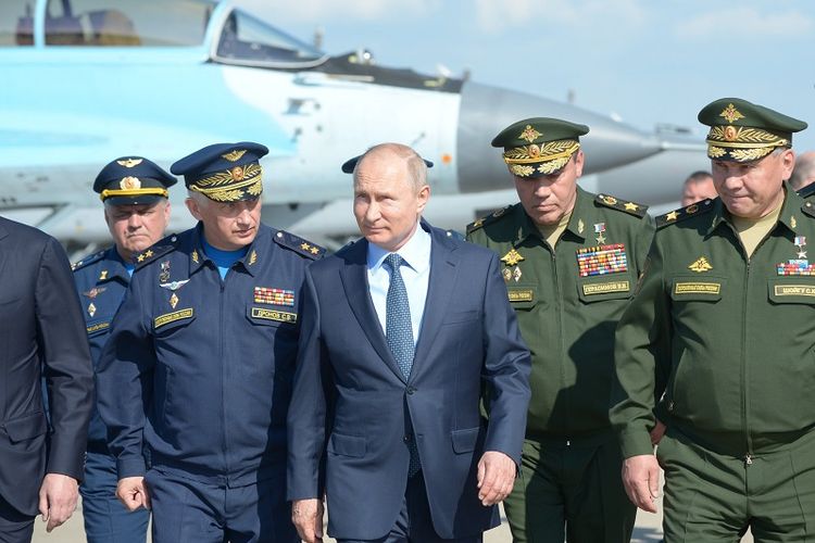 Presiden Rusia Vladimir Putin bersama para pejabat militer saat meninjau pusat uji coba terbang militer di Akhtubinsk. 