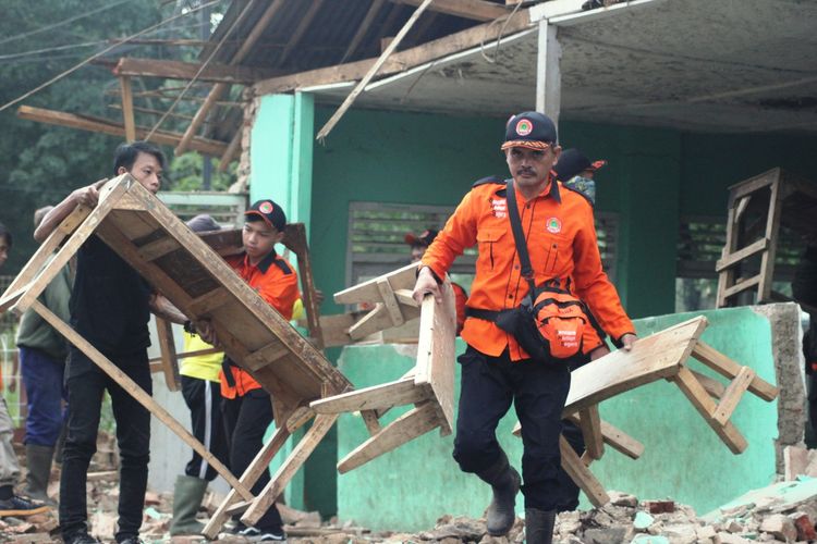 Warga bergotong-royong membersihkan puing-puing bangunan madrasah diniyah di wilayah Cibeber, Kabupaten Cianjur, Jawa Barat, yang ambruk akibat hujan lebat disertai angin kencang.