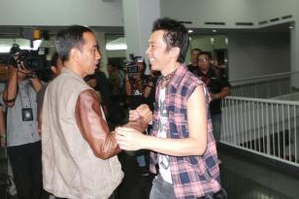 Gubernur DKI Jakarta Joko Widodo (kiri) bersalaman dengan Bimo Setiawan atau Bimbim, drummer Slank, jelang konser grup musik tersebut di Stadion Utama Gelora Bung Karno, Jumat (13/12/2013) malam.