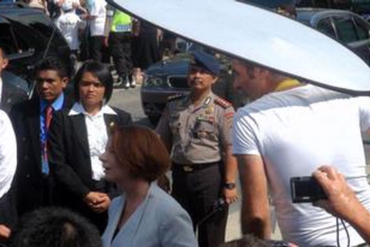 Perdana Menteri Australia Julian Gillard tak keberatan saat salah seorang Cameraman TV Australia meletakkan reflector tepat di atas kepalanya saat memberi keterangan pers kepada wartawan di depan monumen bom Bali, Ground Zero, Kuta, Sabtu (13/10/2012).