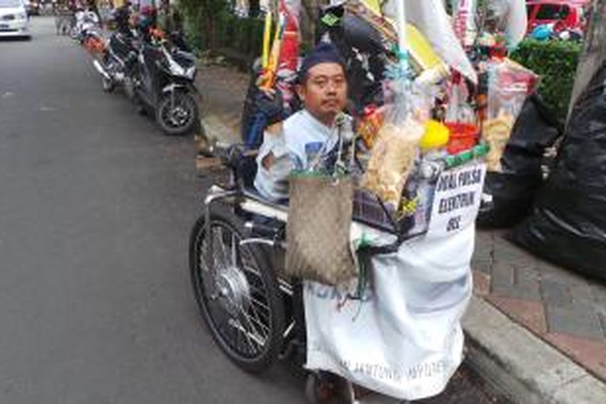 Kundiarto (39) memanfaatkan kursi rodanya untuk berjualan di wilayah Jakarta Selatan. Senin (6/1/2014).