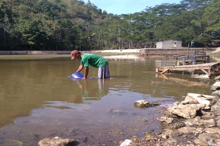 Warga Dusun Ngricik, Desa Melikan, Kecamatan Rongkop, Gunungkidul, Yogyakarta,  Mengambil Air Telaga Banteng Dusun Setempat Minggu (26/5/2019)