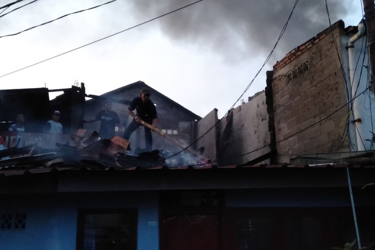 warga padamkan api dari puing puing yang ada di atap rumah saat peristiwa kebakaran di kawasan Kebayoran Lama, Jakarta Selatan, Senin (27/1/2020)