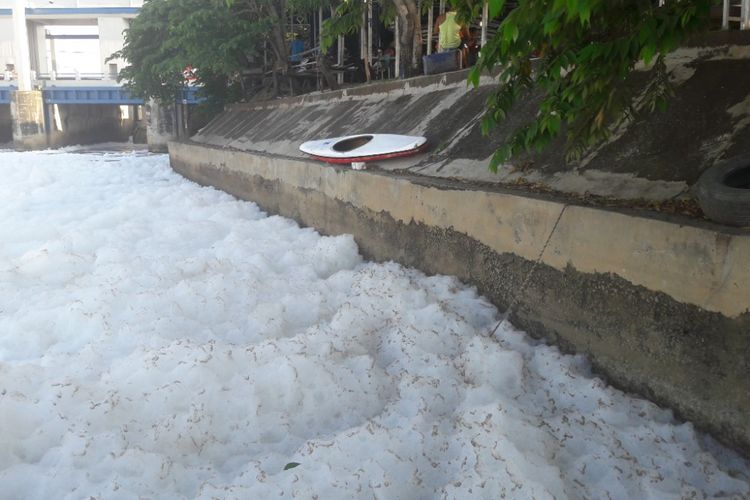 Sebuah perahu kayak milik Persatuan Olahraga Dayung Seluruh Indonesia (PODSI) DKI Jakarta di tepi Kanal Banjir Timur yang dipenuhi busa.