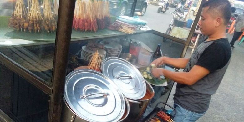 Agus, menyiapkan sate di Kawasan Jasbret, Kota Lhokseumawe, Aceh, Senin (2/4/2018).