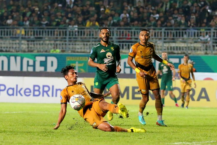 Pemain Dewa United Nasir menghalau tendangan yang mengarah ke pemain Persebaya Surabaya Paulo Victor saat pertandingan pekan ke-34 Liga 1 2022-2023 melawan Dewa United yang berakhir dengan skor 3-0 di Stadion Gelora Joko Samudro Gresik, Sabtu (15/4/2023) malam.