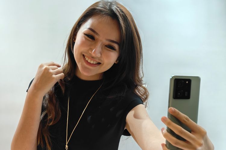 Seorang model memperagakan gaya pengambilan gambar selfie menggunakan Xiaomi 13T di acara peluncuran di Jakarta Selatan, Selasa (3/10/2023). 