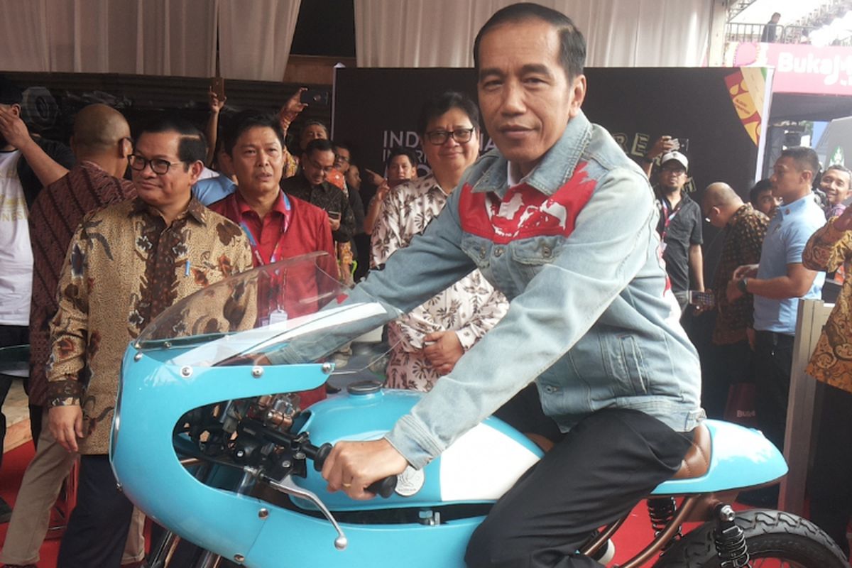 Presiden Joko Widodo menaiki salah satu sepeda motor Honda CB 125 lawas yang dipamerkan di stan Increase saat berlangsungnya hari pertama pameran Indonesia International Motor Show (IIMS) 2018, di JIExpo Kemayoran, Jakarta, Kamis (19/4/2018). Motor yang dimodifikasi bergaya caferacer merupakan milik putra sulung Jokowi, Gibran Rakabuming.