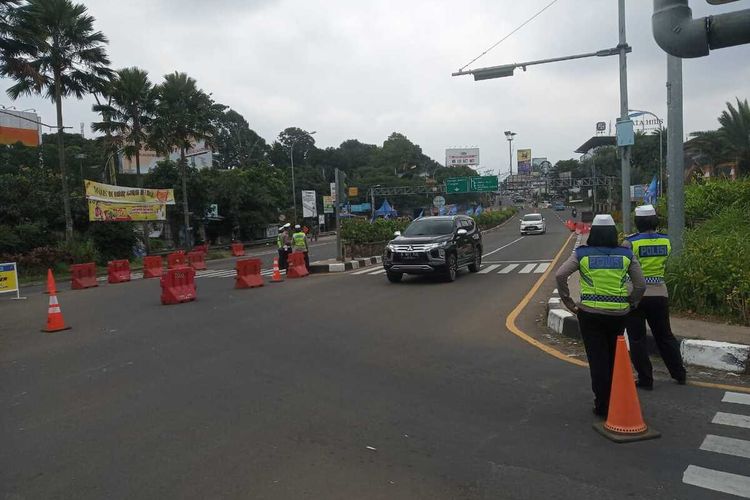Petugas kepolisian tengah mengatur Rekayasa lalu lintas sistem one way atau satu arah turun ke bawah atau Jakarta di Simpang Gadog, Ciawi, Kabupaten Bogor, Jawa Barat, Minggu (26/9/2021).
