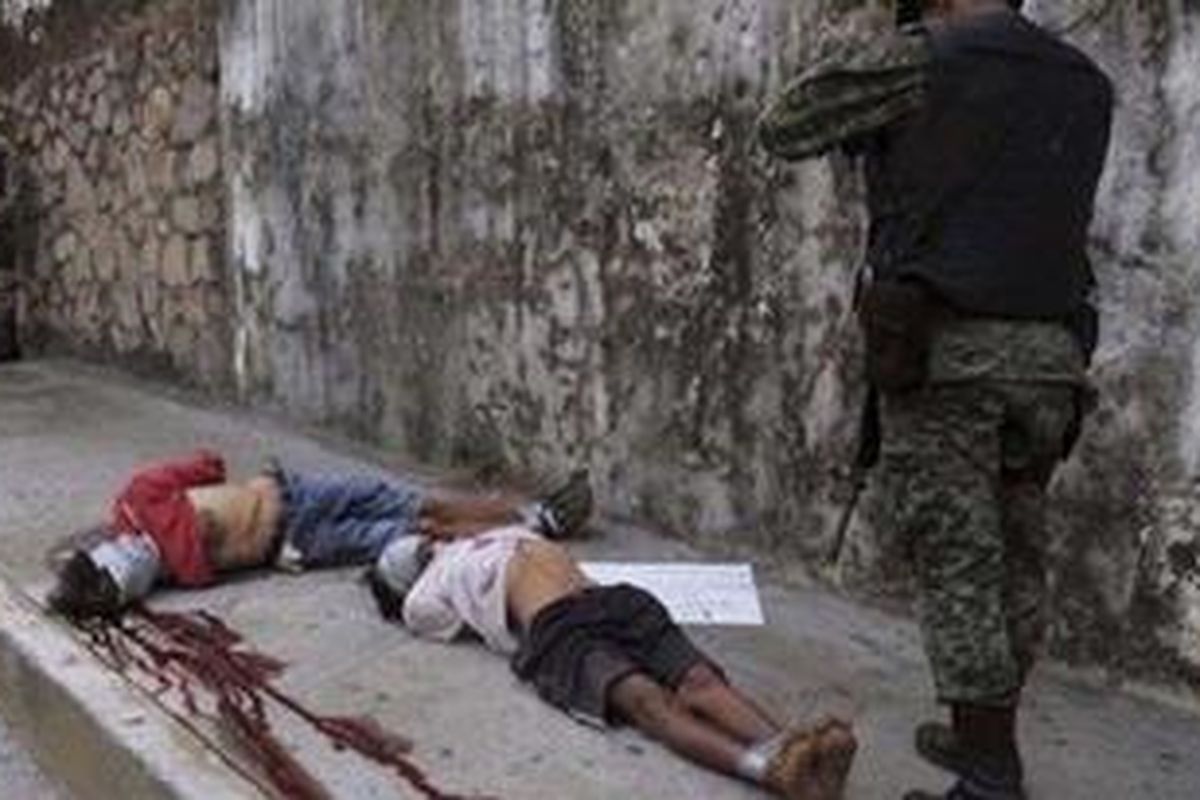 Marinir Meksiko menyelidiki 2 jasad korban serangan bersenjata oleh anggota kartel obat bius di Acapulco, 5 Februari 2010 silam. Ini kota resor yang rawan perang antargeng narkoba.