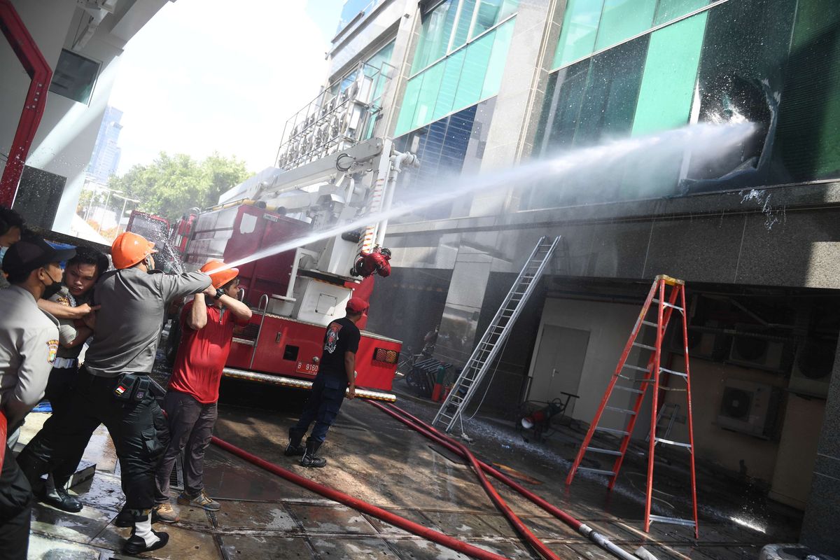 Petugas berusaha memadamkan  kebakaran yang terjadi di Gedung Cyber I, Mampang, Jakarta, Kamis (2/12/2021). Dinas Penanggulangan Kebakaran dan Penyelamatan Jakarta mengerahkan 100 personel beserta 22 unit mobil pemadam ke lokasi. Api berhasil dipadamkan dalam waktu 30 menit.