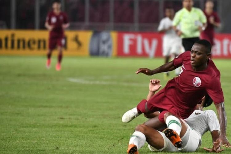 Penyerang timnas U-19 Qatar, Abdulrasheed Umaru, saat berebut bola dengan salah satu pemain timnas U-19 Indonesia pada laga babak penyisihan Grup A Piala Asia U-19 2018 di Stadion Gelora Bung Karno, Minggu (21/10/2018).