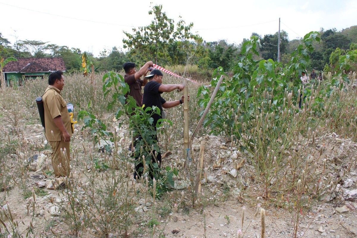 Petugas dari Kejari Gunungkidul memasang garis Adhyaksa di Kalurahan Sampang, Gedangsari.