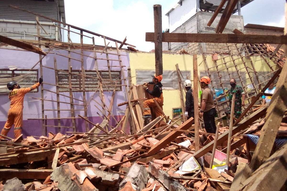 Petugas BPBD Kota Bogor sedang membersihkan material atap bangunan Sekolah Dasar (SD) Negeri Ciheuleut 1 dan Ciheuleut 2, Kota Bogor, Jawa Barat, yang ambruk, Senin (28/3/2022).